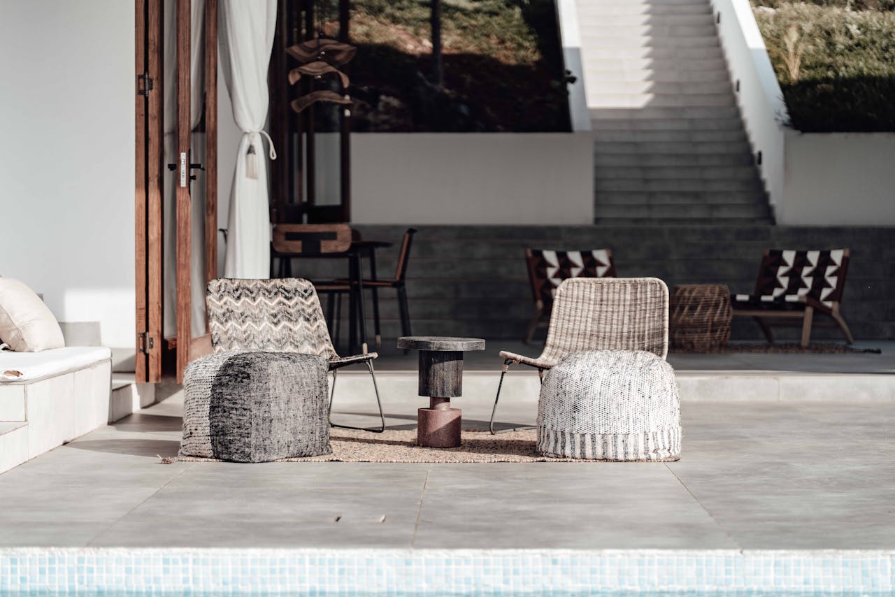services-01 Luxurious outdoor seating arrangement by a pool, featuring modern chairs and decor in a minimalist style.
