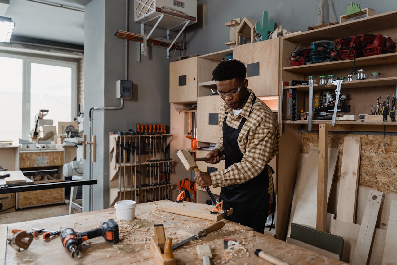 about-img A professional woodworker carving timber in a well-equipped workshop, showcasing craftsmanship.