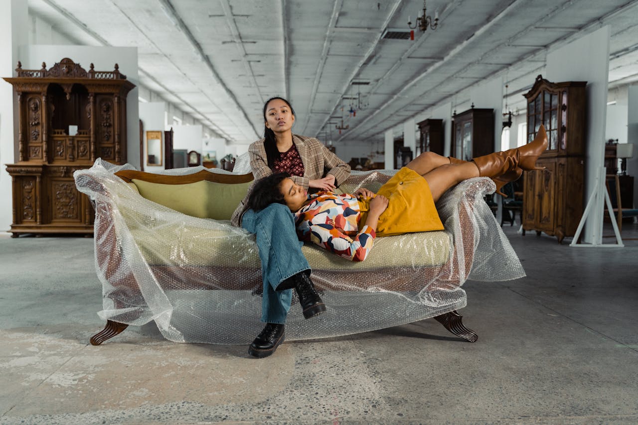 gallery-3 Two women relaxing on a vintage sofa in a retro furniture store.